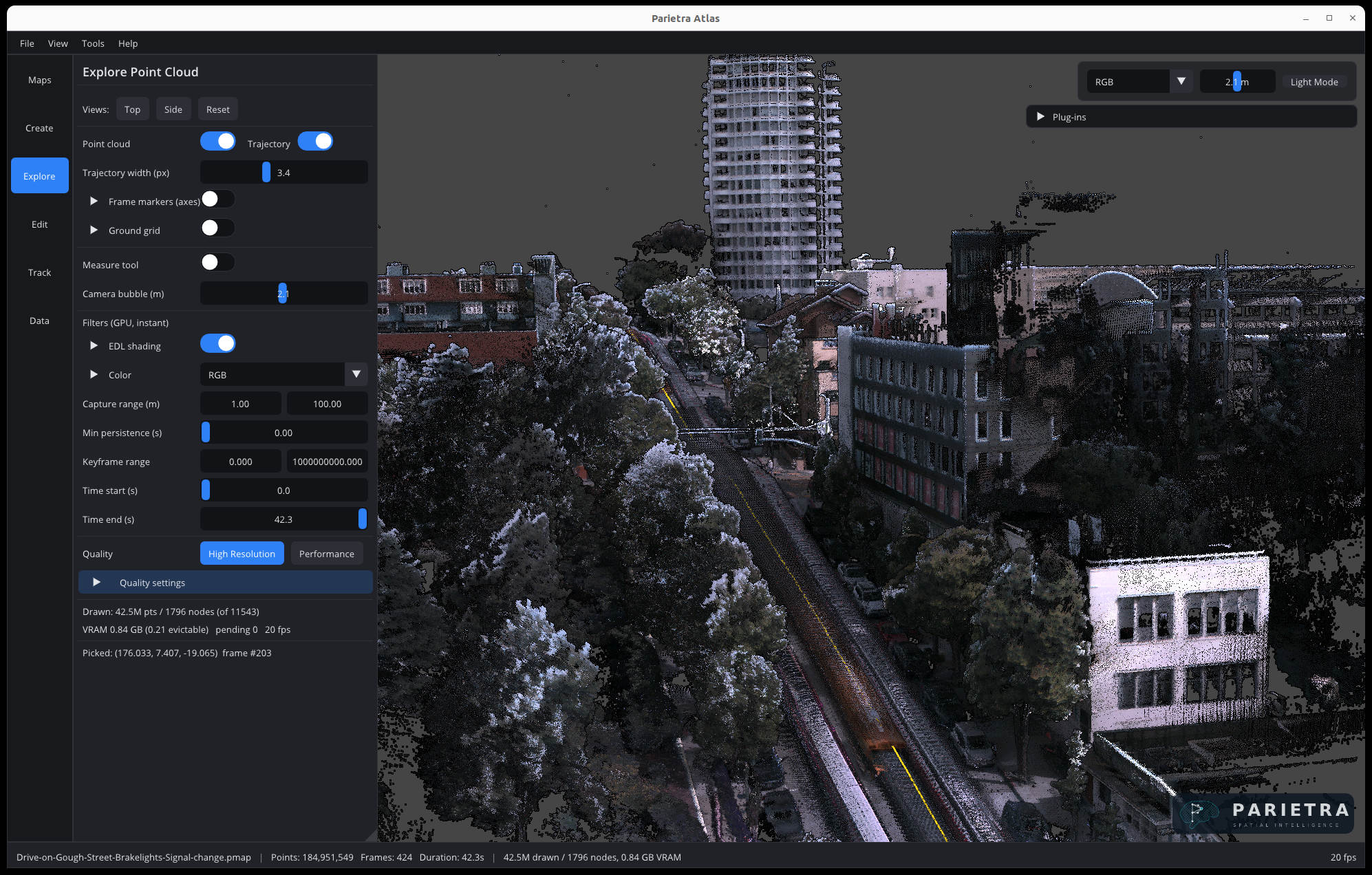 Atlas Explore view of a driven urban capture: an RGB point cloud of a city street with a high-rise, trees, and parked cars, with the capture trajectory drawn along the road.